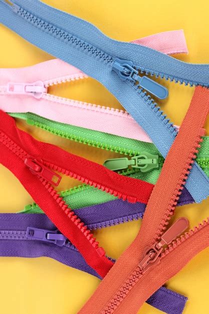 Premium Photo Multicolored Zippers On Yellow Background