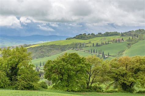 Road On A Hill In A Rural Tuscan Landscape With Rain Clouds Stock Photo
