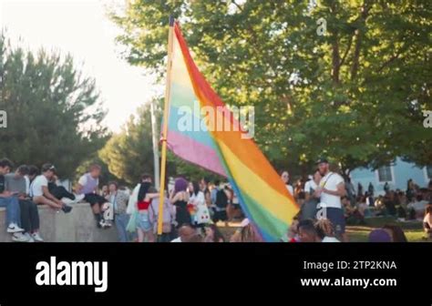 LGBT Flag Fluttering In Wind During Gay Pride Parade Crowd Of People Background Happy Free