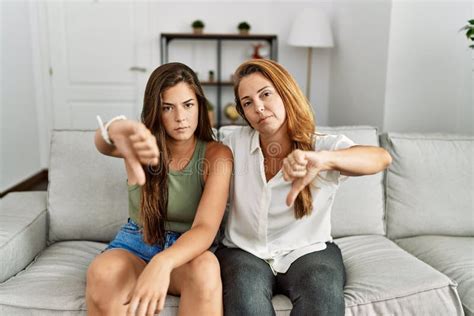 Mother And Daughter Together Sitting On The Sofa At Home Looking