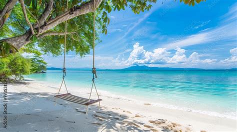 A tranquil tropical beach backdrop features a beach swing or hammock ...