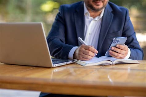 Premium Photo A Mature Business Man In An Outdoor Ambition Working In A Laptop And Phone Blue