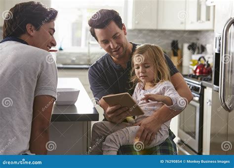 Pareja Gay Masculina Que Usa La Tableta Con Su Hija En Cocina Foto De Archivo Imagen De Hija