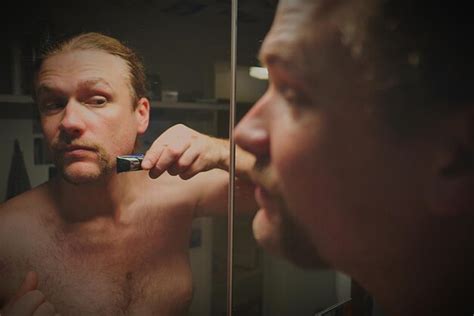 Premium Photo Man Shaving Beard Looking At Mirror