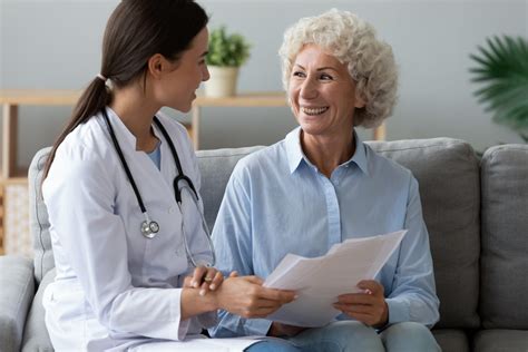 Young woman doctor consult happy old grandmother patient hold papers - Blue Ridge Pain Management