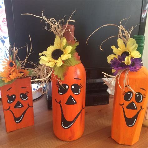 Three Painted Pumpkins With Flowers In Them