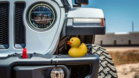 a rubber duck sitting on the front bumper of a jeep