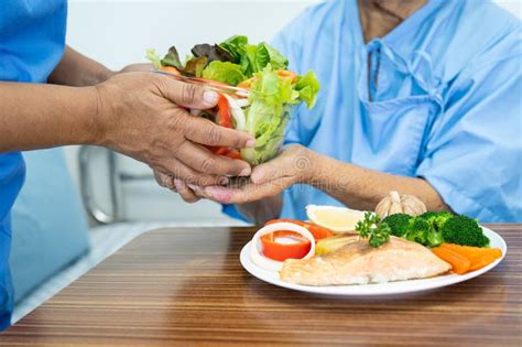 Asian Elderly Woman Patient Eating Salmon Steak Breakfast With