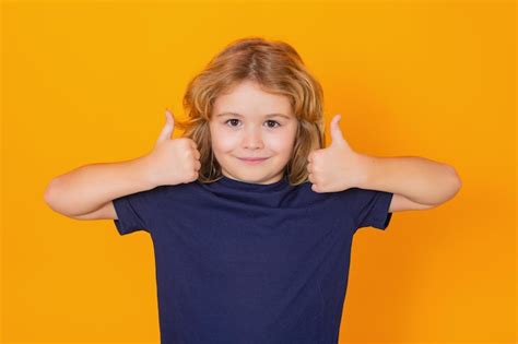 Premium Photo | Child showing thumbs up on studio isolated background ...