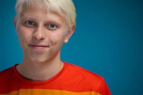 Joven Gay Rubio Con Ojos Azules En Ropa De Comunidad Lgbt Rainbow Sobre Un Fondo Azul Foto