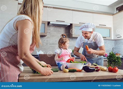 Una Familia Feliz Prepara La Comida En La Cocina Foto De Archivo