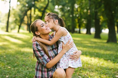Mother And Daughter Outdoors Playing Kissing And Hugging Stock Photo
