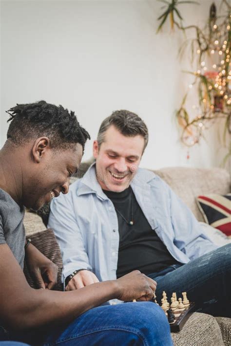 Un Par Gay Que Disfruta De Tiempo Dentro En Casa Jugando A Ajedrez Foto De Archivo Imagen De