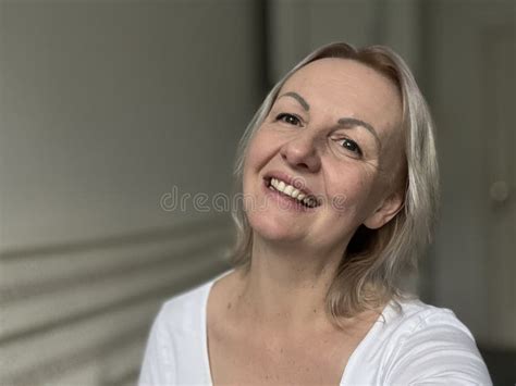 Happy Mature Blonde Lady Sitting On Couch Holding Video Call With Friends Head Shot Close Up