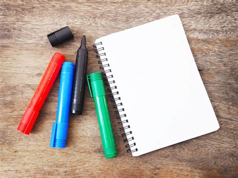 Premium Photo Marker Pens And Notebook On Wooden