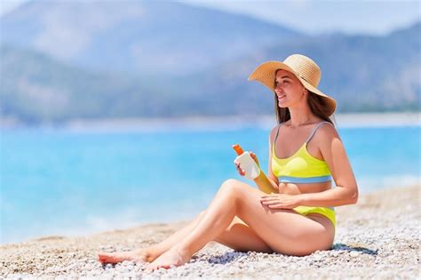 Premium Photo | Young girl applying sunscreen lotion while sunbathing ...