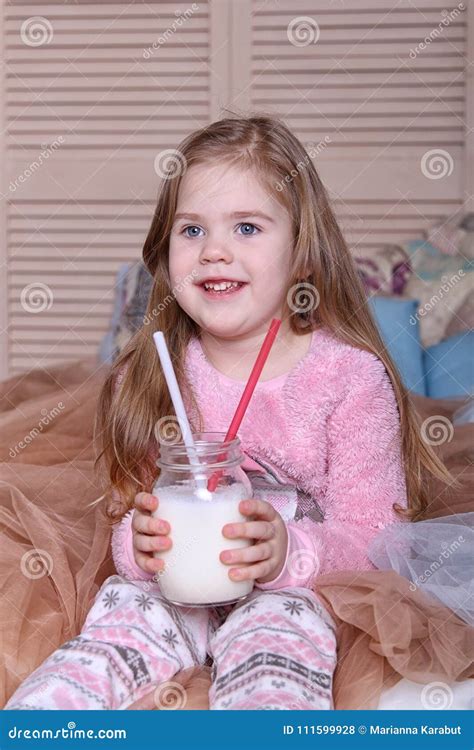 Une Gentille Petite Fille Blonde Sur Le Lit Photo Stock Image Of Adorable Lait