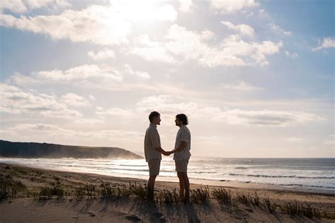 Casal gay de tiro completo na praia Foto Grátis