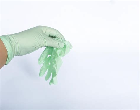 Premium Photo Close Up Of Hand Holding Gloves Over White Background