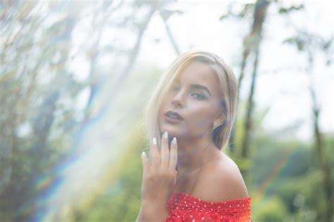 Premium Photo Lovely Blonde Model With Naked Shoulders In Red Dress Posing In Sun Glare
