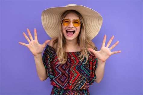 Jeune fille slave blonde mécontente avec des lunettes de soleil et avec un chapeau de soleil