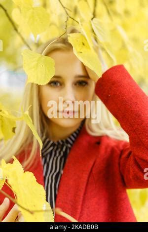 Une jeune femme blonde se promène dans la ville d automne sous un manteau rouge Le concept de