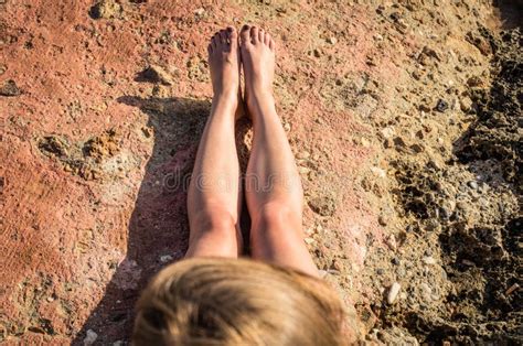 Stretched Naked Legs Of A Tanning Woman Sitting On The Rocks Stock Photo Image Of Long Bikini