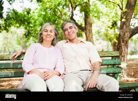 Mature Couple Sitting On A Park Bench And Smiling Lodi Gardens New Delhi India Stock Photo