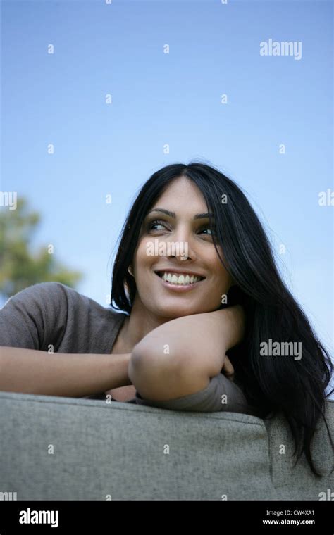 Attractive Brunette Son On A Sofa In The Garden Stock Photo Alamy