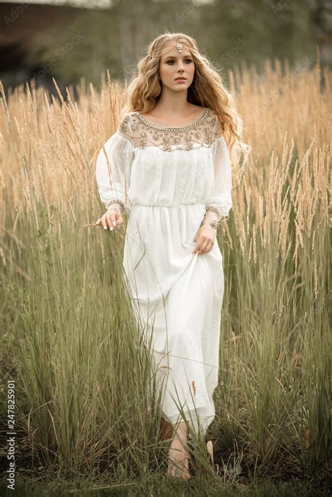 Portrait Of Happy Smiling Blonde Girl With Long Blonde Hair Is Wearing White Bridal Fashion