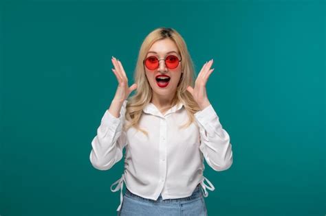 Jolie fille jeune jolie fille blonde dans une chemise blanche choquée et surprise dans des