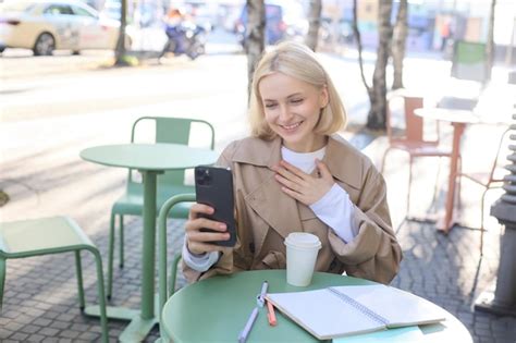 Jeune Mannequin Blonde Heureuse Dans Un Caf Parle En Chat Vid O En Utilisant Un Smartphone Et
