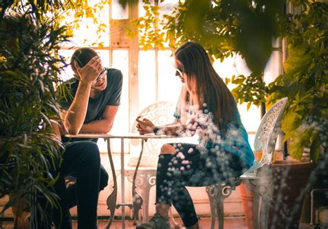 Man And Woman Sitting On Chairs Beside A Table · Free Stock Photo