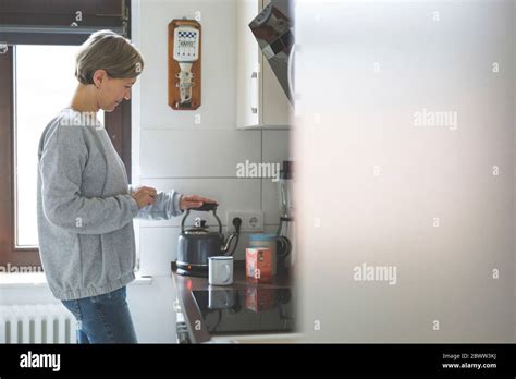 Mature Woman Preparing Tea In Kitchen Stock Photo Alamy