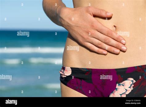 Woman In Bikini Bottom Hand On Abdomen Mid Section Stock Photo Alamy