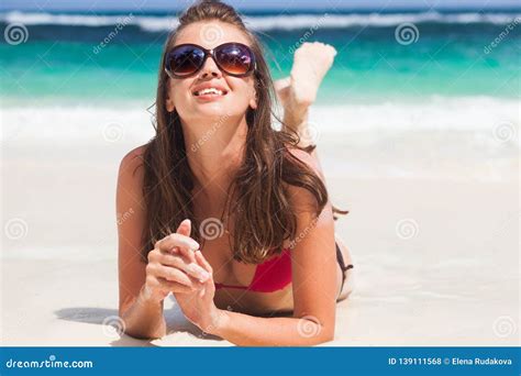 Retrato De La Mujer De Pelo Largo En Bikini Rojo Y Las Gafas De Sol Que Mienten En La Playa