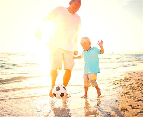 dad  son playing soccer   beach   proud  support hope