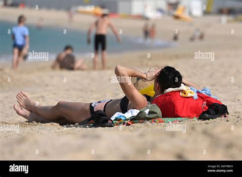 Schlanke Frau Im Bikini Liegt Am Januar Allein Am Strand Le Mer In Dubai Stockfotografie