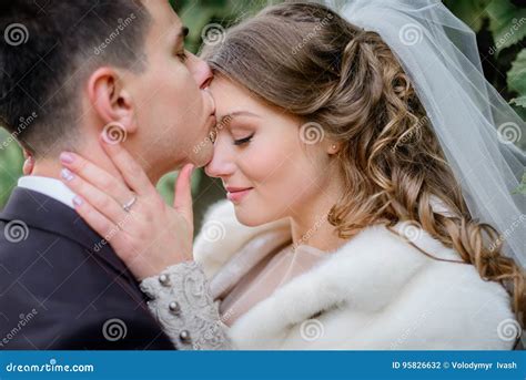 Brunette Groom Kisses Bride X S Forehead Tenderly Stock Photo Image Of Happy Beauty