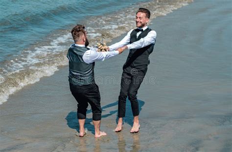 Gay Man With Partner On Wedding Day Gay Grooms Walking Together On Sea Beach During Wedding Day