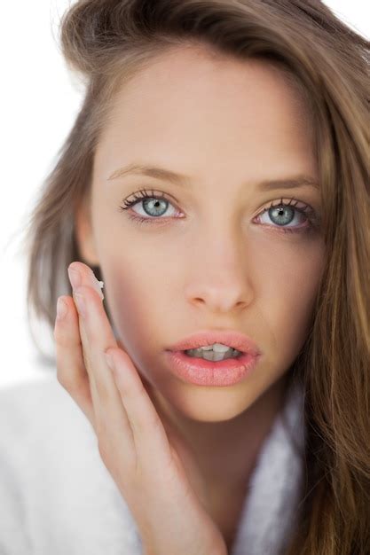 Premium Photo Pensive Brunette In Bathrobe Rubbing Her Cheek With Cream