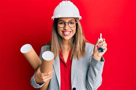 Beautiful Brunette Woman Wearing Safety Helmet Holding Blueprints Smiling With A Happy And Cool
