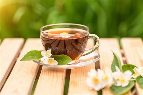 Uma Xícara De Chá Perfumado Em Uma Mesa De Madeira Decorada Flores