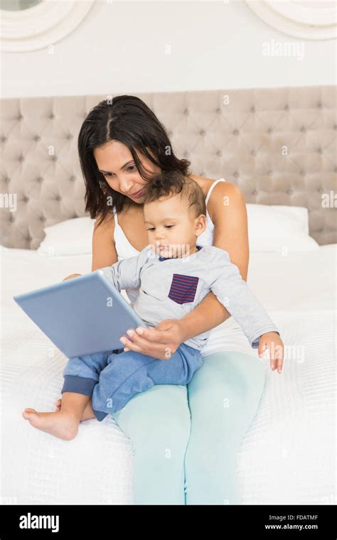 Happy Brunette Holding Her Baby And Using Tablet Stock Photo Alamy