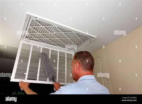 male dusting     home furnace intake air vent grid stock