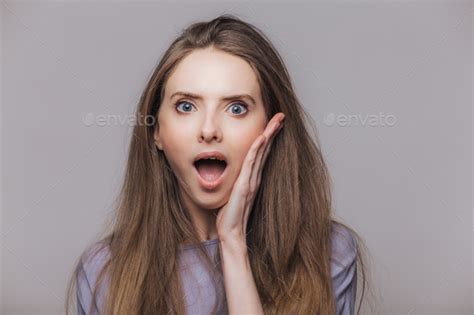Portrait Of Amazed Surprised Brunette Female Keeps Mouth Widely Opened Stock Photo By StudioVK