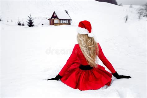 Merry Christmas Beautiful Blonde Woman In Red Dress And Santa Clause Hat On A Background Of