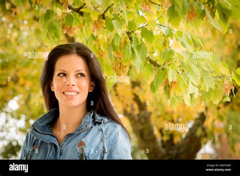 Beautiful Brunette Girl Taking A Walk By A Park In Autumn Stock Photo Alamy