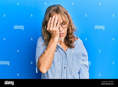 Femme blonde d âge moyen portant des vêtements et des lunettes décontractés bâillonne fatiguée