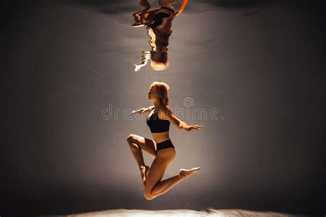 Girl With An Athletic Figure And Blond Hair In Black Lingerie Dives